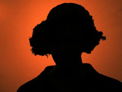 Silhouette of a person stretching against a dark background.